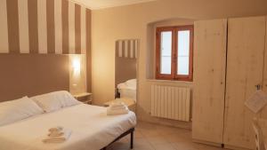 a bedroom with a bed with two towels on it at Hotel La Smorfia in Castiglioncello