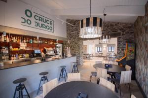 a restaurant with tables and chairs and a bar at Hotel Rural O Cruce do Burgo in Friol