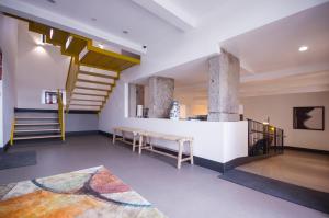 a living room with a staircase and a stair case at Hotel Rural O Cruce do Burgo in Friol