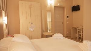 a room with a bed and a door with towels at Hotel La Smorfia in Castiglioncello