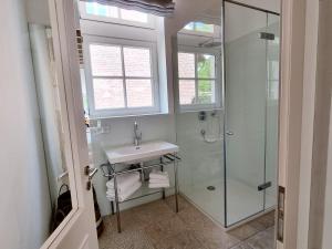 a bathroom with a sink and a glass shower at THUERS IM BUSCH - Gute Stube - ab 3 Nächte - Ferienwohnungen mit Stil in Münster in Münster