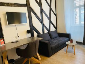 a living room with a couch and a desk at Altstadt Hotel Glockenhof in Eltville