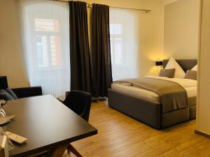 ein Schlafzimmer mit einem Bett und einem Tisch in einem Zimmer in der Unterkunft Altstadt Hotel Glockenhof in Eltville