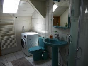 a bathroom with a toilet and a sink and a washing machine at Wohnung in der "Alten Post" in Hohenhameln