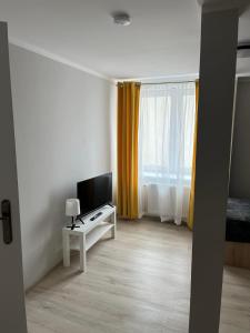 uma sala de estar com televisão e uma mesa com televisão em Pokoje na Górce em Rajgród