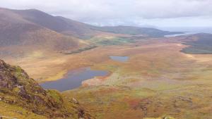 an aerial view of a mountain valley with a lake at Teach Eoin in Dingle