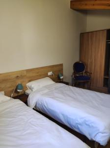 um quarto de hotel com duas camas e uma cadeira em APT 3 Àtic acollidor al Centre de Vic - APTGARBI em Vic