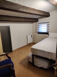a bedroom with two beds and a window in it at APT 3 Àtic acollidor al Centre de Vic - APTGARBI in Vic