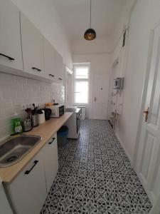 a kitchen with a sink and a tile floor at Sunny rooms at Danube in Budapest
