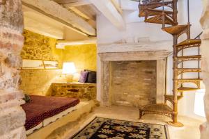 a bedroom with a fireplace and a bed and a ladder at Casa Pereta in Magliano in Toscana
