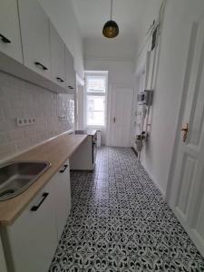 a kitchen with a sink and a tile floor at Sunny rooms at Danube in Budapest