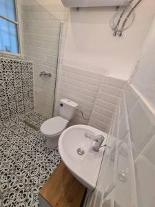 a white bathroom with a toilet and a sink at Sunny rooms at Danube in Budapest