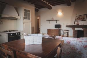 Campiglia dʼOrciaにあるAgriturismo La Paciarellaのキッチン(木製テーブル、椅子、コンロ付)