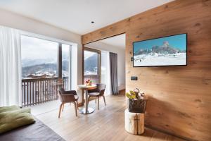 un salon avec une télévision sur un mur en bois dans l'établissement Residence Hotel Eden - Family & Wellness Resort, à Andalo