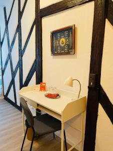 a white desk with a chair and a picture on the wall at Altstadt Hotel Glockenhof in Eltville