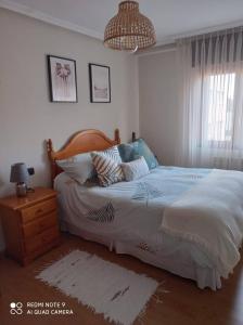 1 dormitorio con 1 cama grande y mesita de noche en Bermejo Apartamento, en Candás