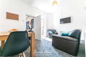 a living room with a table and two leather chairs at Severn Street House Serviced Accommodation in Leigh