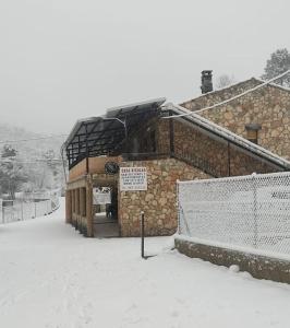 ein schneebedecktes Gebäude mit einem Schild davor in der Unterkunft CASA NICOLAS in Molinicos