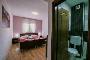 a small bedroom with a bed and a bathroom at Villa Marinko in Međugorje