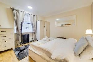 een slaapkamer met een groot wit bed en een raam bij The Quebec Residence in Londen