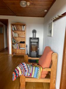 a living room with a chair and a stove at Ferienhaus am Steinmeister Turm in Naumburg