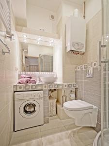 uma casa de banho com uma máquina de lavar roupa e um WC em Apartament Kameralny III na Starówce em Gdansk