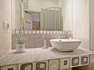 a bathroom with a sink and a large mirror at Apartament Kameralny III na Starówce in Gdańsk