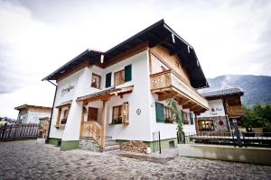 un edificio blanco con balcón en una calle en Chalet & Apartments Tiroler Bua, en Achenkirch