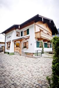 a large white house with a stone driveway at Chalet & Apartments Tiroler Bua in Achenkirch