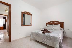 una camera da letto con un letto con uno specchio sul muro di Casa Rosi a Gran Tarajal