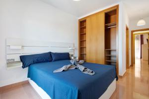 Un dormitorio con una cama azul con una cinta. en Casa Rosi 2, en Puerto del Rosario