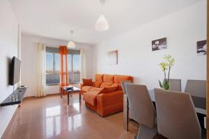 a living room with an orange couch and a table at Casa Rosi 2 in Puerto del Rosario