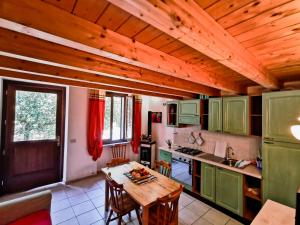 cocina con armarios verdes y techo de madera en Le Rose Marine, en Isola Rossa