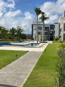 ein großes Gebäude mit einem Pool und Palmen in der Unterkunft Estancia Mónaco, Hard Rock CANA BAY in Punta Cana