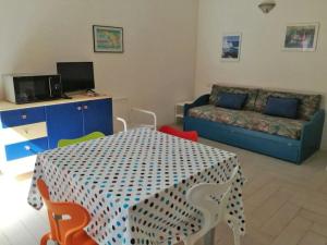 Una sala de estar con una mesa y sillas y un sofá. en Le Rose Marine, en Isola Rossa