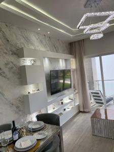 a living room with a dining table and a television at Estancia Mónaco, Hard Rock CANA BAY in Punta Cana +26 photos