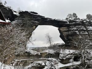 un arco in un muro di pietra con la neve sopra di U Vaclava a Hřensko