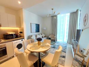 a kitchen and living room with a table and chairs at Perfect 1 BR for Family Stay - Close to Downtown in Dubai