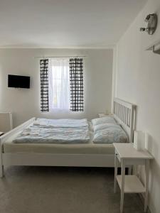 una camera da letto bianca con un letto e una finestra di U Vaclava a Hřensko