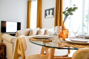 a dining room with a table with plates and wine glasses at Beach Waves Apartment in Faro