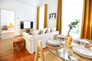 a living room with a white couch and a glass table at Beach Waves Apartment in Faro