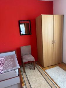 a bedroom with a bed and a chair and a cabinet at Apartman Zaga in Trebinje