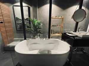 baño con bañera grande y lavamanos en KP Hotel, en Can Tho