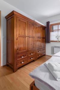 a large wooden cabinet in a bedroom with a bed at Apartma Metka in Medvode