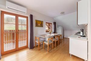 cocina con mesa y sillas y cocina con ventana en Apartma Metka, en Medvode