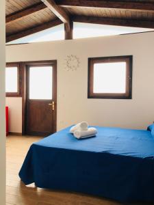 a bedroom with a blue bed with a clock on the wall at Baia Dei Micenei in Otranto
