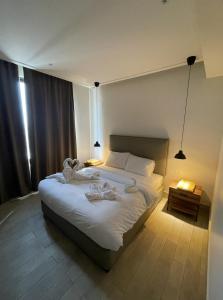 a bedroom with a large bed with white sheets at Zerø Føur DeadSea in Sowayma