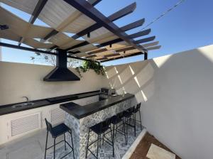 an outdoor kitchen with a bar with stools at Zerø Føur DeadSea in Sowayma