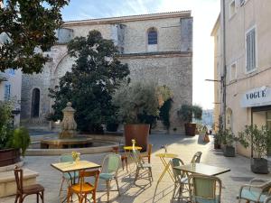 a patio with tables and chairs in front of a building at Vieux port LA CIOTAT 1 in La Ciotat