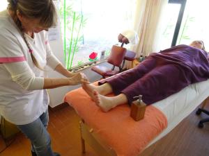 una mujer se está lavando los pies en una cama en Casa da Marina, en Aljezur